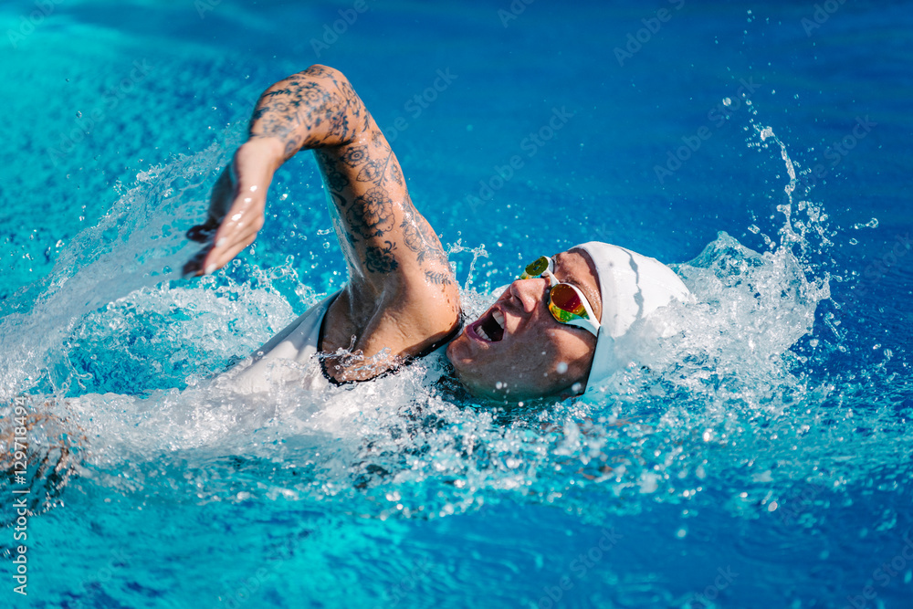 Female front crawl swimmer with tattoos