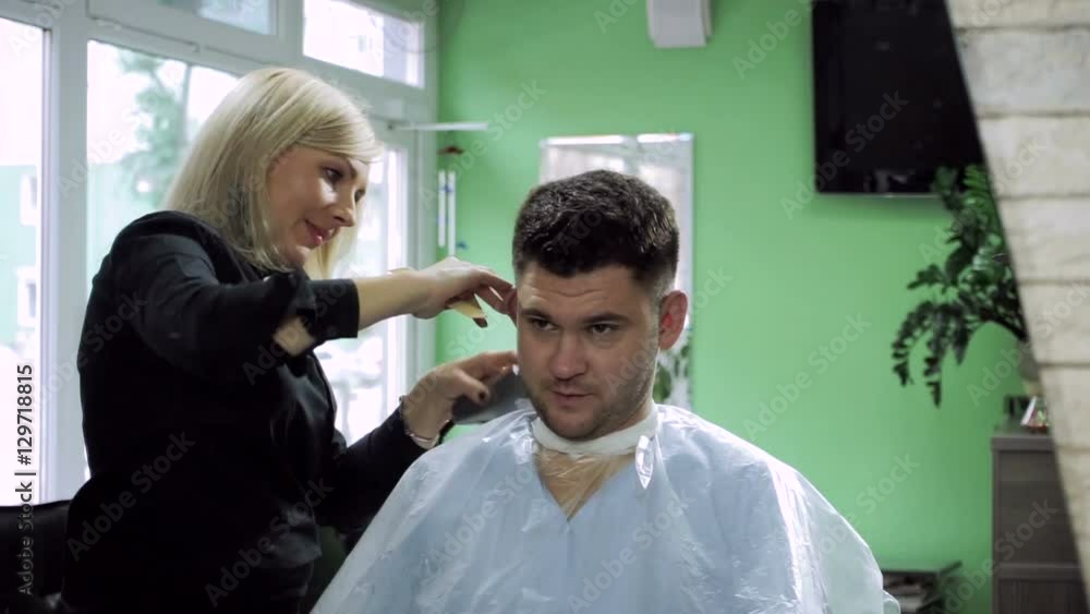 Haircut at barber's. Female hairdresser shaping men's hair into a style by cutting. HD Haircut at barber's. Female hairdresser shaping men's hair into a style by cutting. HD