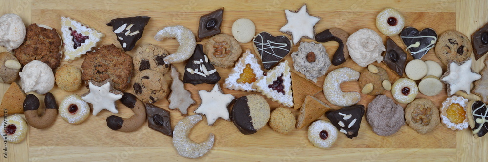 ribbon out of different kinds of Christmas cookies on a breadboard ribbon out of different kinds of Christmas cookies on a breadboard