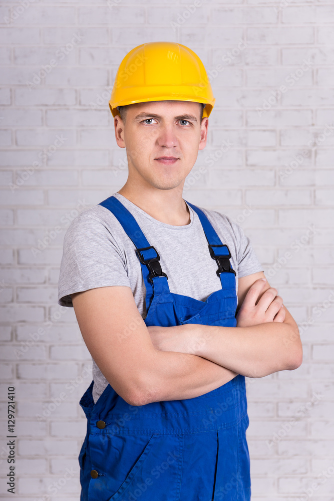 builder in uniform posing over white wall builder in uniform posing over white wall