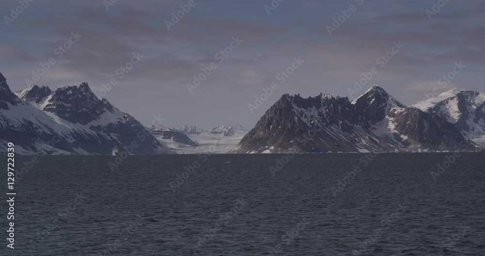Passing Snowy Coastal Mountains in Arctic on Sunny Day Passing Snowy Coastal Mountains in Arctic on Sunny Day