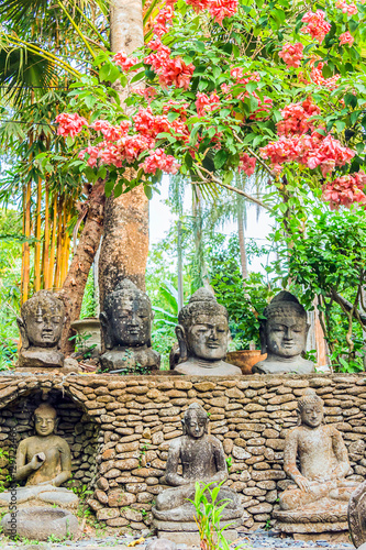 Stone buddhas surrounded by flowers