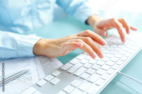 Woman office worker typing on the keyboard