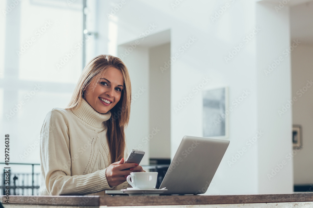 Successful business woman looking at mobile cell phone while at Successful business woman looking at mobile cell phone while at