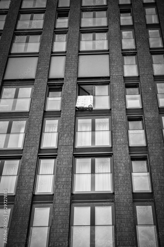 High storey building with windows and a bed cover hanging and drying High storey building with windows and a bed cover hanging and drying