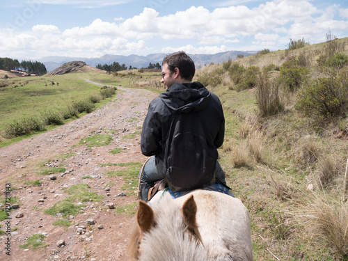 Canvas Print Young man horse ridding at sacred valley in Cusco, Peru.