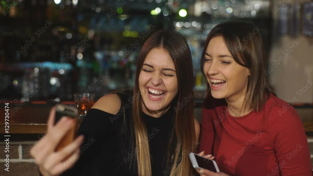 two beautiful women take a selfie at the bar two beautiful women take a selfie at the bar