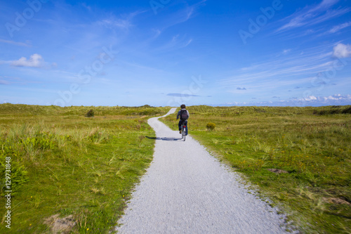 People cycling on a bike path through the dune landscape of Frisian Island Amsland, the Netherlands