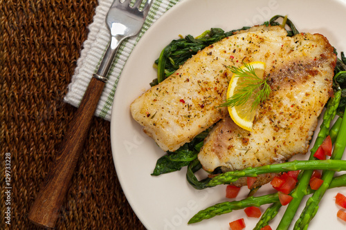 Baked Fish Fillet with Sauteed Spinach. Selective focus.