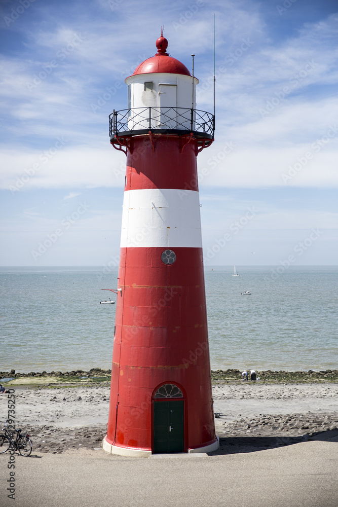Fototapeta premium Red and white lighthouse on a blue sky background, Westkapelle, The Netherlands