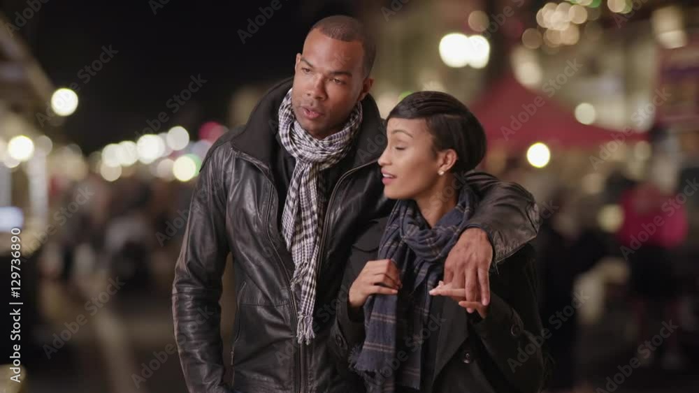 A young black couple talks at a market in the city A young black couple talks at a market in the city
