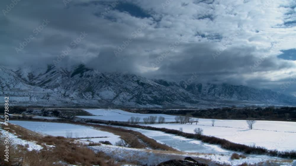 Winter Farmland Time-lapse. Fast moving clouds over a snow covered Wyoming farmland mountainside. Winter Farmland Time-lapse. Fast moving clouds over a snow covered Wyoming farmland mountainside.