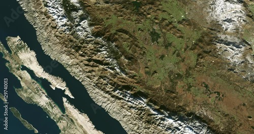 High-altitude overflight aerial of the Dinarnic Alps along Croatia's Adriatic coast. Clip loops and is reversible. Elements of this image furnished by USGS/NASA Landsat 