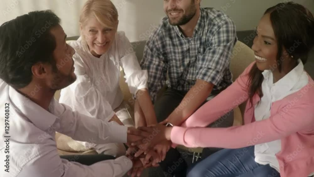 Group of business executives forming handstack Group of business executives forming handstack
