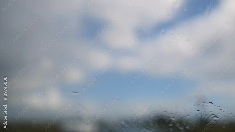 Summer highway on a rainy day - defocused background. Moving waterdrops in the windshield Summer highway on a rainy day - defocused background. Moving waterdrops in the windshield