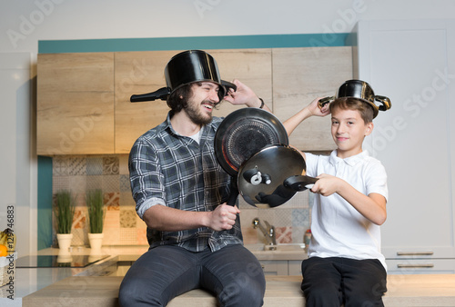 father and kid having great time in kitchen. Father and son havi photo