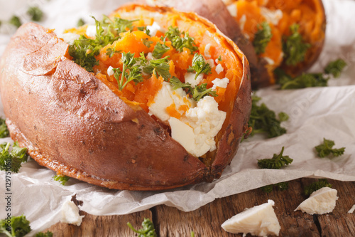 sweet potatoes baked with feta cheese and parsley macro on the table. Horizontal