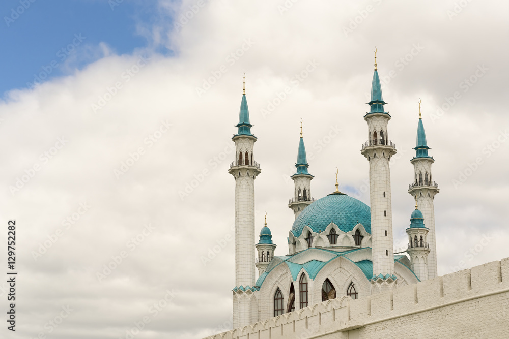 Beautiful white mosque with blue roof against the sky with clouds