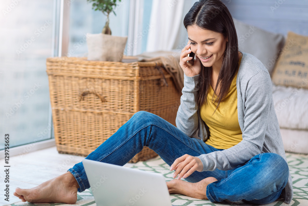 Positive young woman speaking over the phone at home Positive young woman speaking over the phone at home