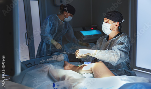 doctor and an assistant in operating room for surgical venous va