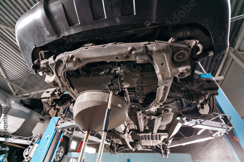 Change engine oil. working underneath a lifted car