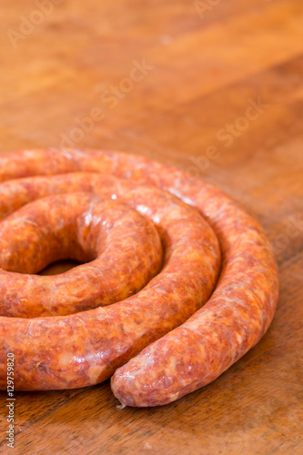 Rolled raw red sausage on the table