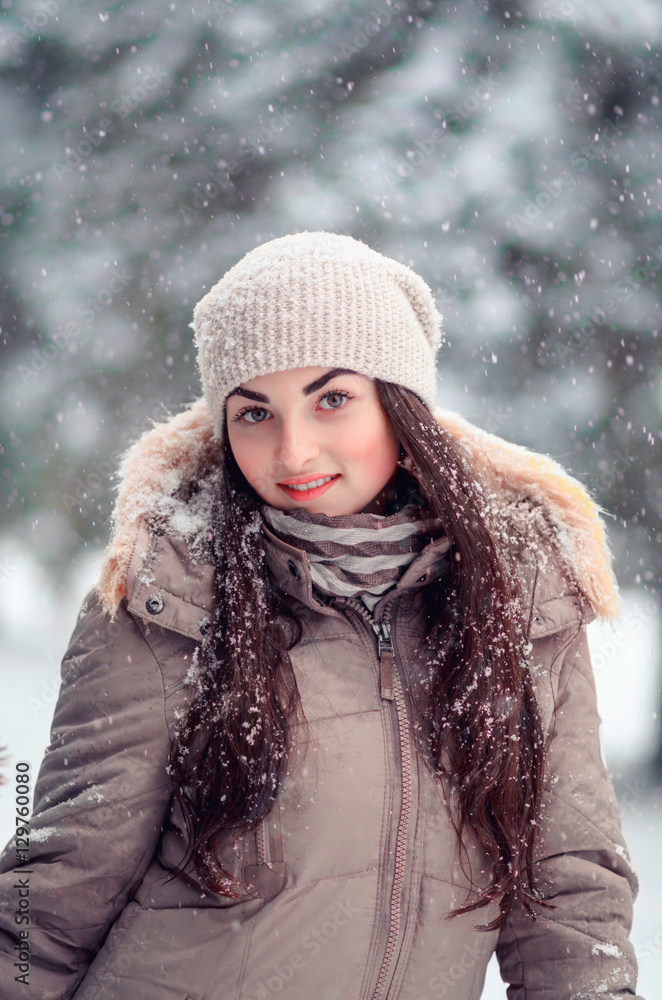 cheerful girl winter portrait in the snowfall. cheerful girl winter portrait in the snowfall.