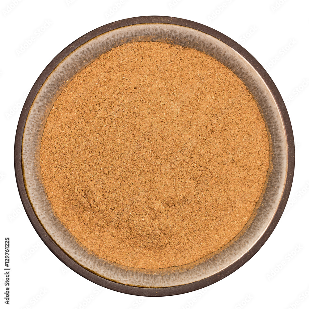 Organic cinnamon powder in ceramic bowl isolated on white background, top view Organic cinnamon powder in ceramic bowl isolated on white background, top view