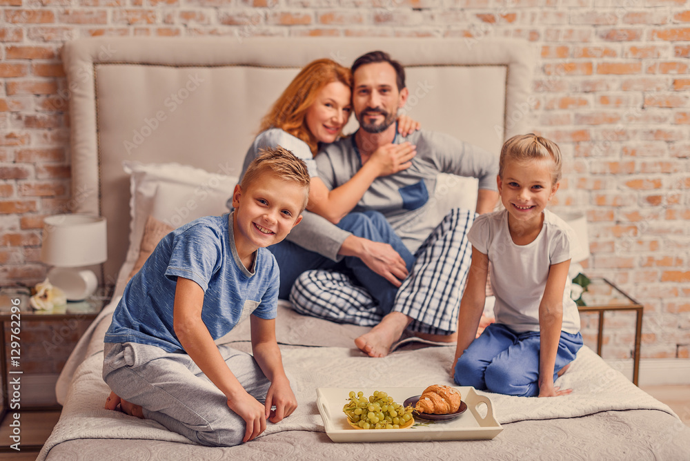 Happy family lying down on bed at home Happy family lying down on bed at home