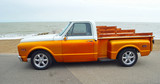  Classic Gold and white pickup truck on seafront promenade with sea in background
