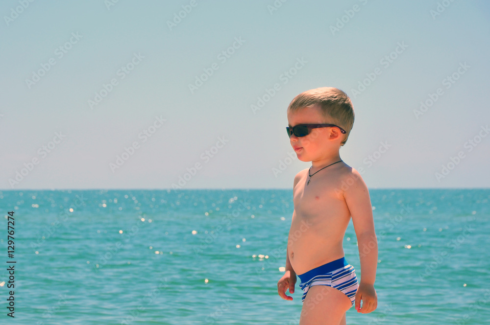 the little boy in sunglasses at the sea