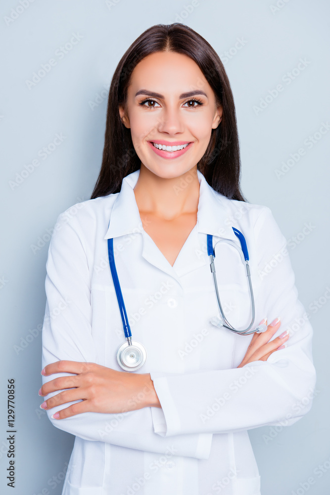 Portrait of pretty female doctor with beaming smile and crossed Portrait of pretty female doctor with beaming smile and crossed