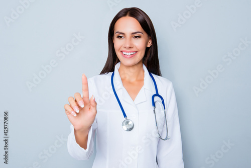 Female doctor in white uniform touching virtual screen