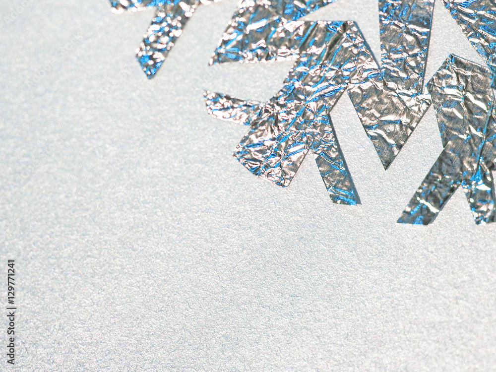 foil snowflake on a silver background foil snowflake on a silver background