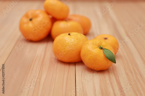 Mandarin Oranges with a small leaf on wooden background