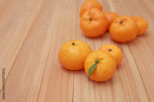 Mandarin Oranges with a small leaf on wooden background