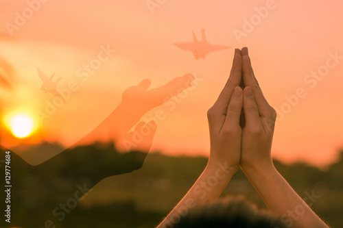 Silhouette people pray from Buddha statue to hope for help on sun set and bokeh background. Inspiration from help to hope, Put the palms of the hands together in salute.