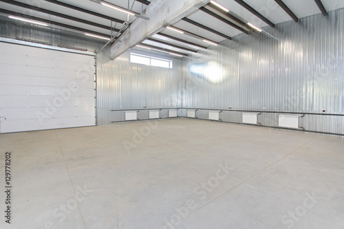 empty parking garage, warehouse interior with large white gates and windows inside