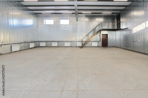 empty parking garage, warehouse interior with large white gates and windows inside