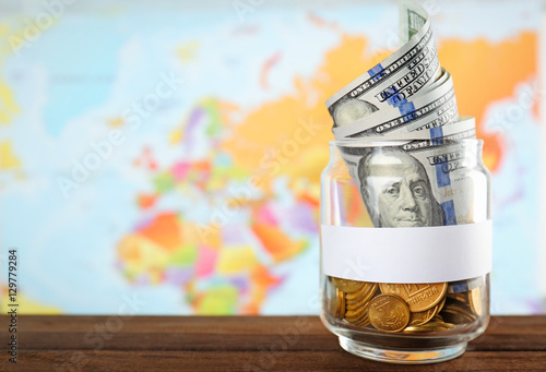 Glass jar with money on wor...