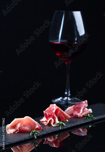 jamon and red wine on a black background