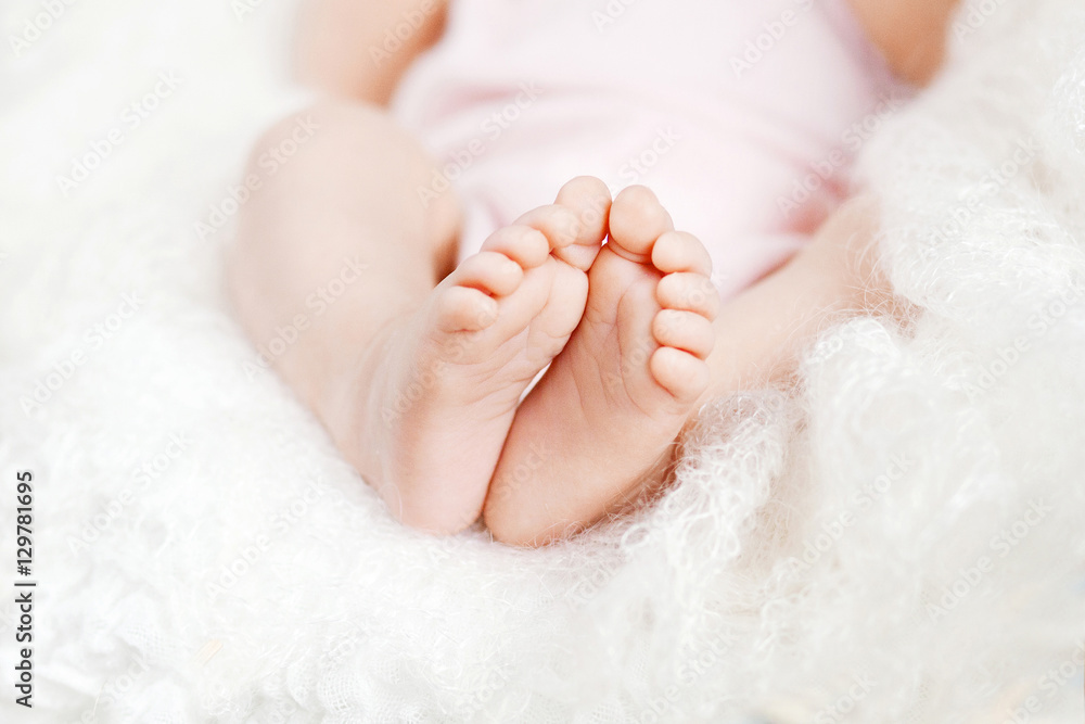 Close up picture of newborn baby feet in knitted plaid Close up picture of newborn baby feet in knitted plaid