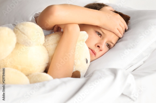 Small sick boy with Teddy b...