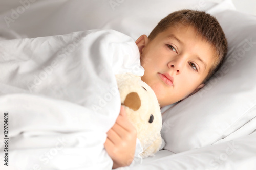 Small sick boy with Teddy b...