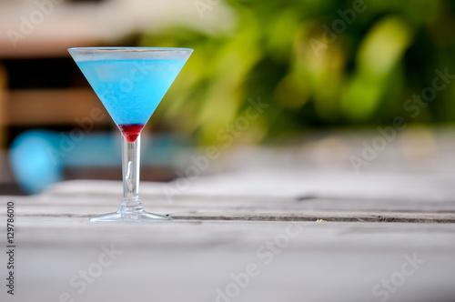 Frozen Blue Margarita Cocktail, blue cocktail on the wooden table, blurry background