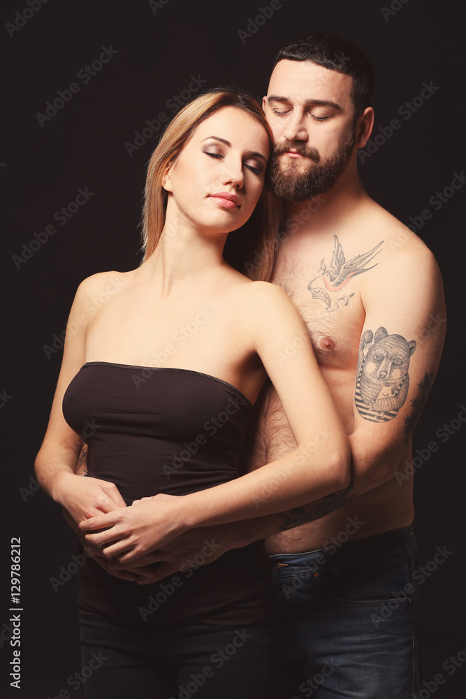 Portrait of romantic tattooed couple on black background Portrait of romantic tattooed couple on black background