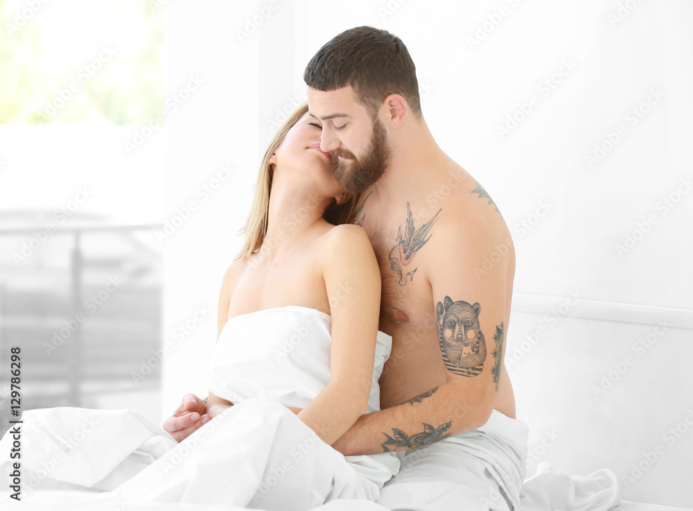 Young tattooed couple hugging at bed Young tattooed couple hugging at bed