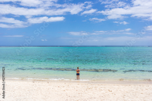 Woman is going to swim on beautiful beach in Mauritius