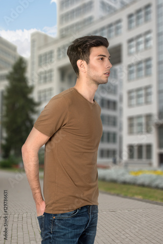  the young  man in a t-shirt and jeans in city photo