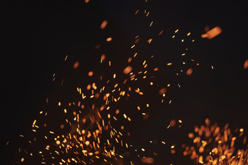 sparks from bonfire over dark night environment, shallow focus